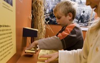 Kinder arbeiten in der Ausstellung 'Stroh' mit den Texttafeln