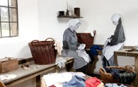 Eine nachgestellte Szene in der Ausstellung 'Textile Wege': Zwei Frauen sortieren Lumpen