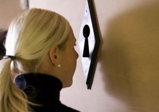 Eine Frau schaut durch eines der Schlüssellöcher