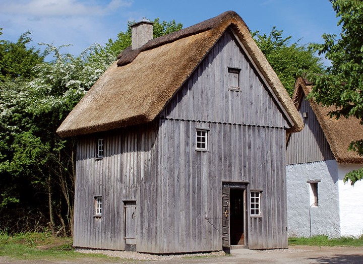 Das zweigeschossige Backhaus im LVR-Freilichtmuseum Lindlar ist zum Schutz mit Brettern verkleidet. Das Das ist mit Reet gedeckt.