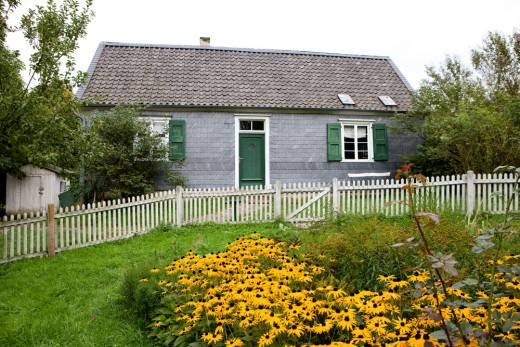 Das Bandweberhaus der Familie Thiemann: Blick über den blühenden Garten zur Eingangstür in der verschieferten Fassade