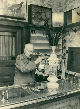 Fritz Römer Junior zapft hinter der Jugendstil-Theke mit dem bemalten Zapfaufsatz aus Porzellan ein Bier
