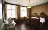 Blick in das Elternschlafzimmer im ersten Obergeschoss. Die Einrichtung mit edlen Hölzern lässt den Wohlstand der Familie erkennen.