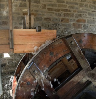 Das Wasserrad des Müllershammers wird durch Wasser, dass aus dem Rad herausspritzt, angetrieben.