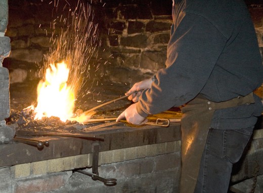 Schmied vor dem lodernden Feuer in der Schmiede aus Lindlar-Linde