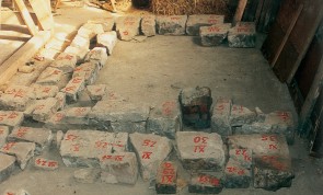 Einzelne Steine eines historischen Gebäudes sind nummeriert und für den Wiederaufbau angeordnet.