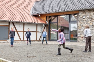 Kinder spielen Federball im Innenhof der Museumsherbgerge