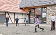 Kinder spielen Federball im Innenhof der Museumsherbgerge