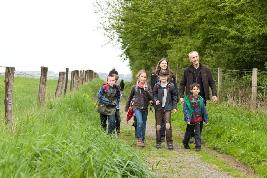 zwei Erwachsene und sechs Kinder wandern auf einem der fünf Museumswanderwege rund um das LVR-Freilichtmuseum Lindlar