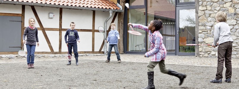 Kinder spielen Federball im Hof der Museumsherberge