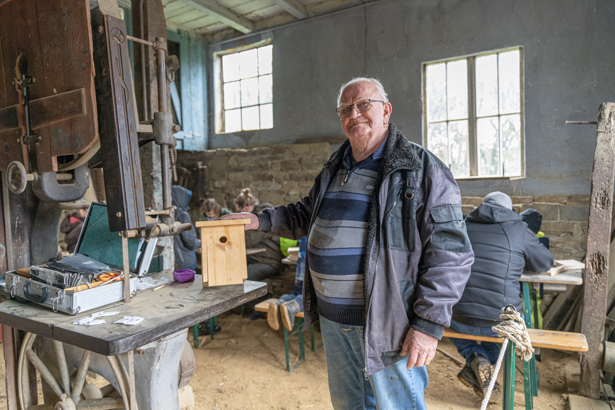 Ein Mann präsentiert ein Vogelhaus