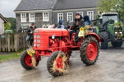 Roter Traktor mit Kränzen geschmückt