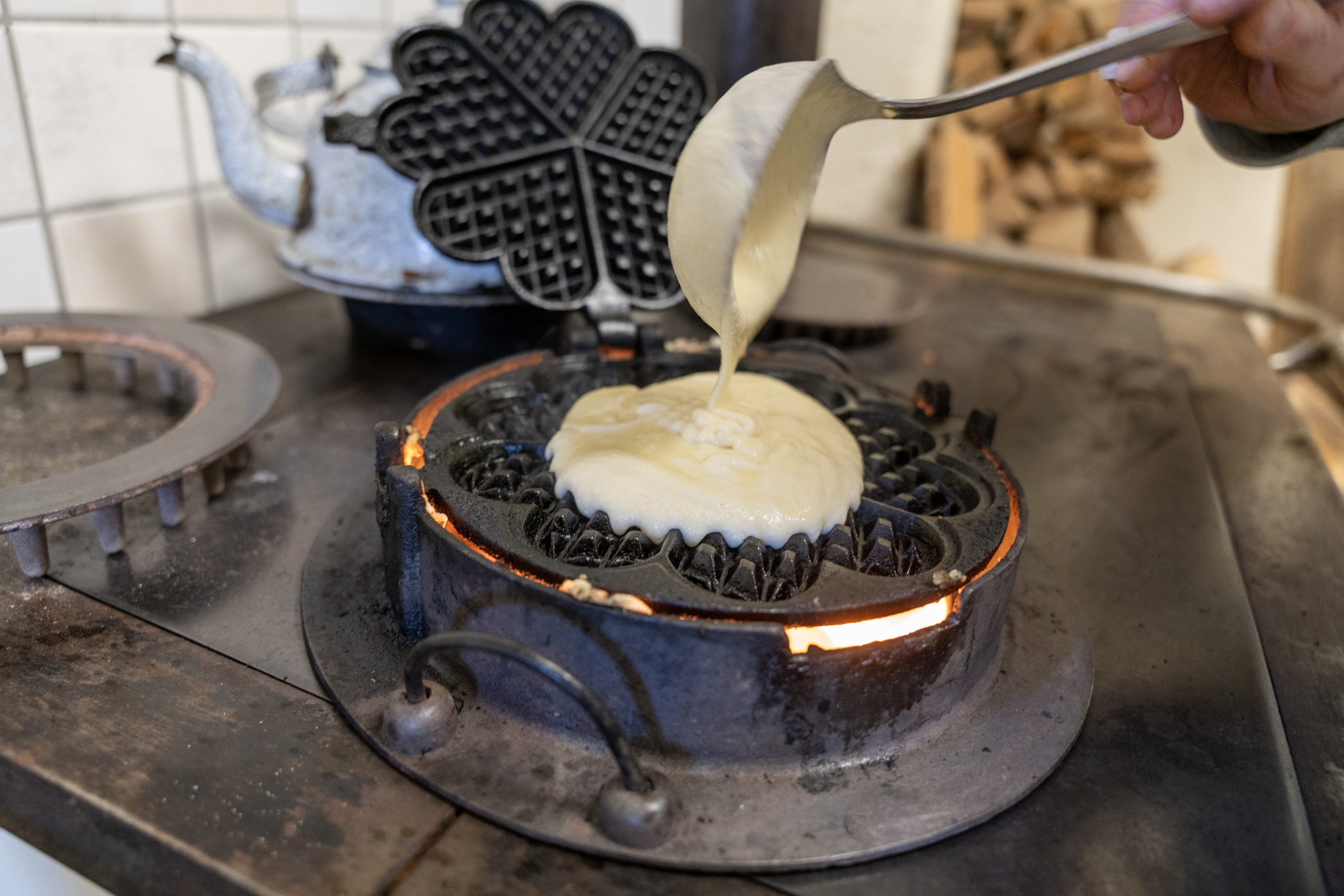 Waffeltag wird in ein historisches Waffeleisen gegossen.