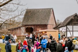 Viele Besuchende tummeln sich auf dem Museumsgelände. Im Hintergrund ein Verkaufsstand, eine Scheune und ein kleines historisches Fachwerkhaus.