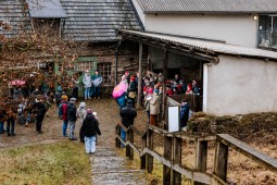 Mehrere Personen hören einem Chor zu, der vor einem der historischen Gebäude auftritt.