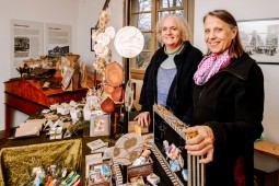Zwei Frauen präsentieren Waren an einem Verkaufsstand in einem der Häuser.