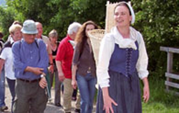 Eine Schauspielerin in historischem Kostüm führt Besucher als Bäuerin Joest über das Gelände des LVR-Freilichtmuseums Lindlar